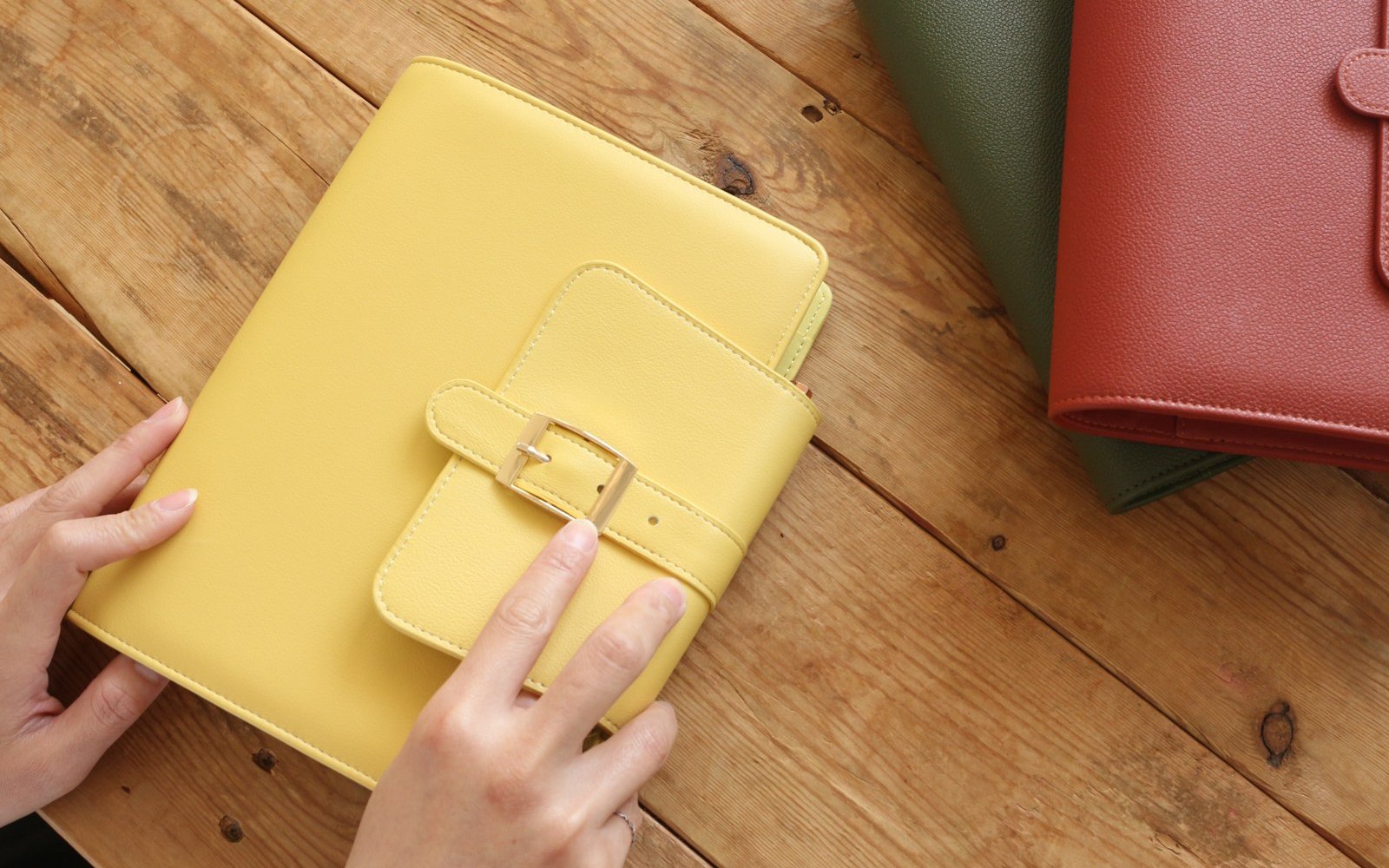 Hands opening the rings of an EGOSUNNY refillable planner to lift out a page