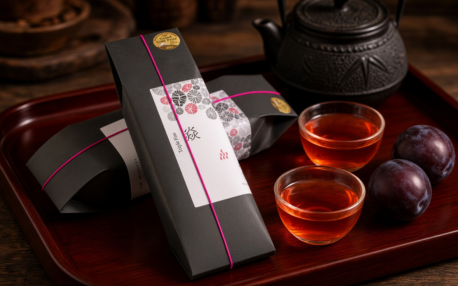 Cangui Guyun Yan (Fire) red oolong sachet box with dark cups of orange-red tea