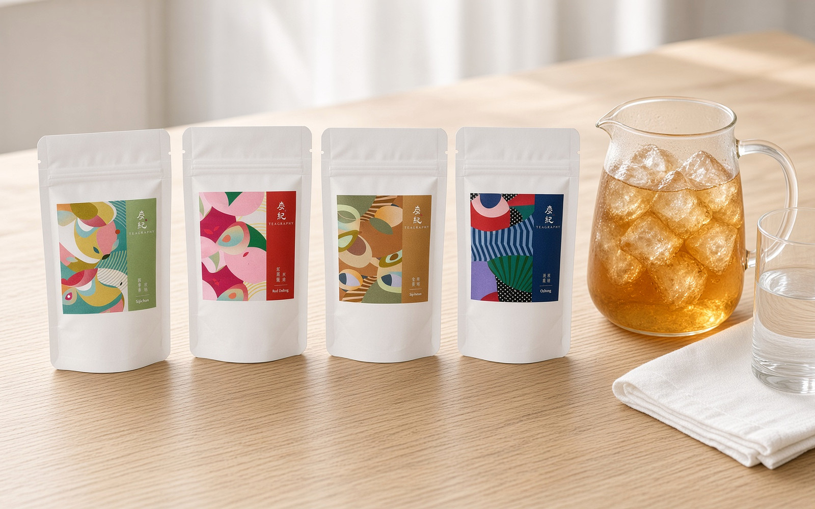 TEAGRAPHY Four Seasons tea bag pouches beside a glass jug of cold-brew oolong