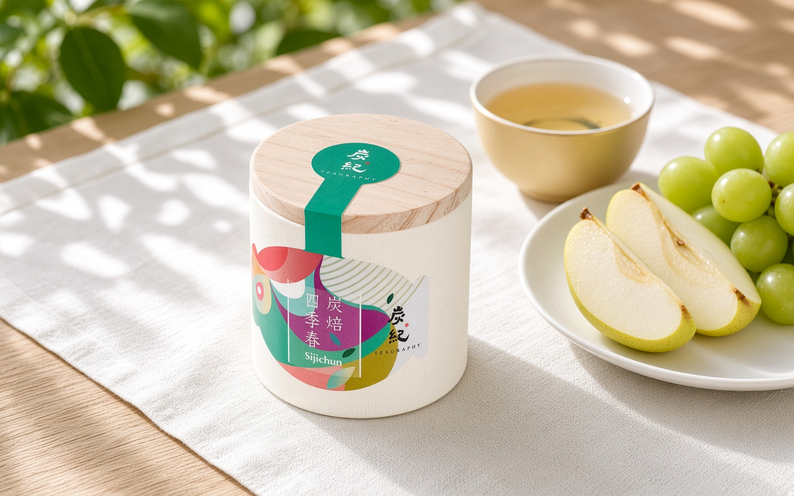TEAGRAPHY Four Seasons Si Ji Chun can beside a light plate of fresh fruit and a pale golden cup