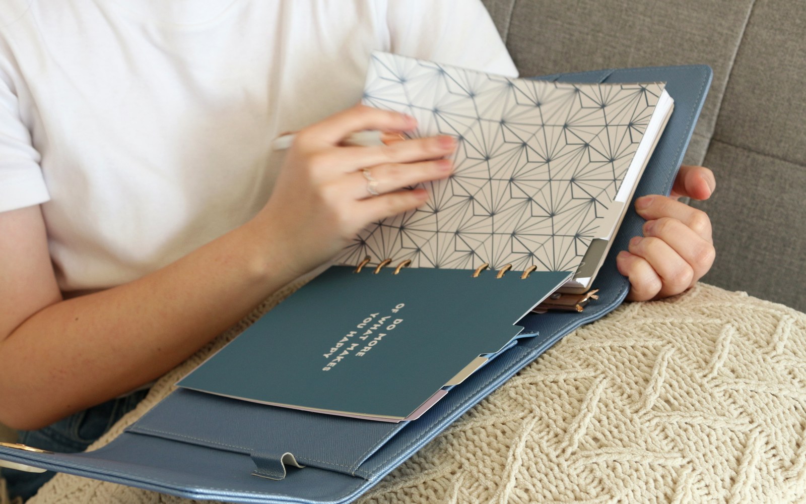 Holding an EGOSUNNY planner with a floral insert on a cosy sofa
