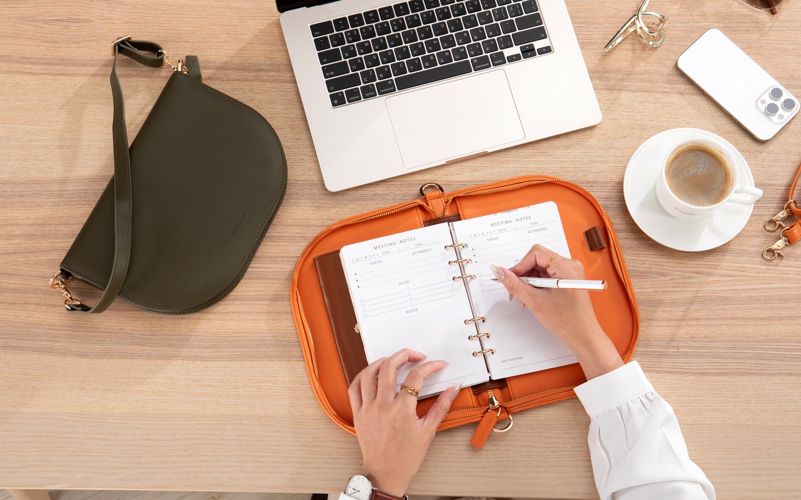 Overhead view of a desk with a laptop and The Luna planner open
