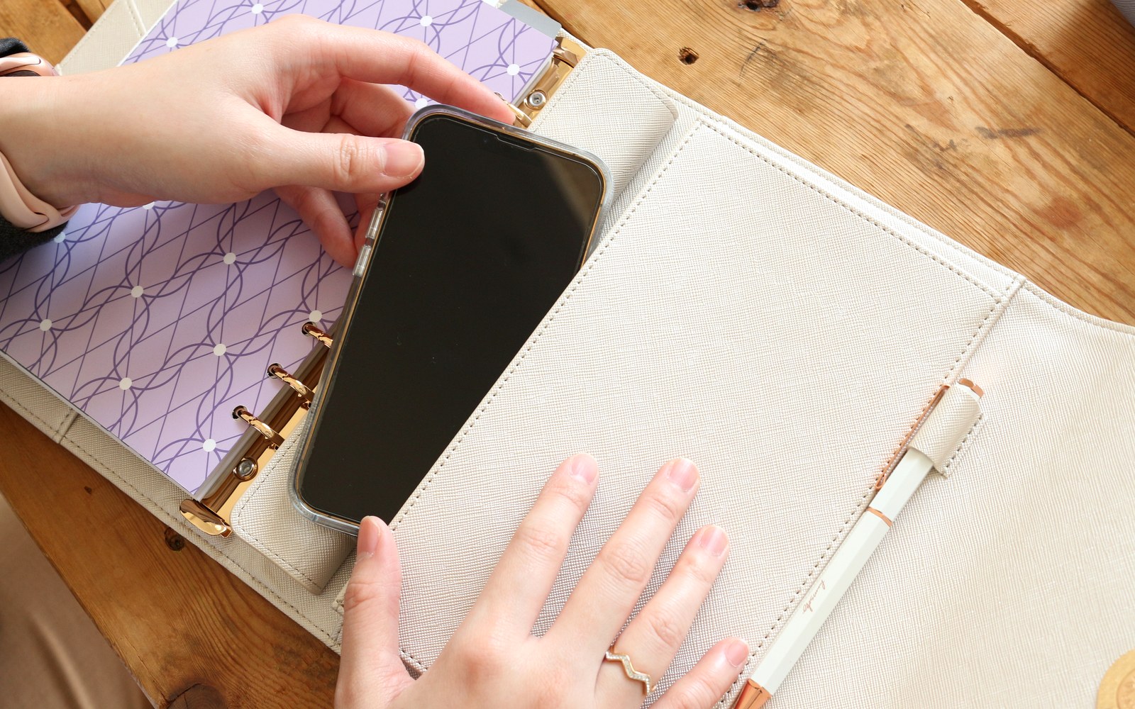 Tucking a phone into an EGOSUNNY planner pocket at the desk