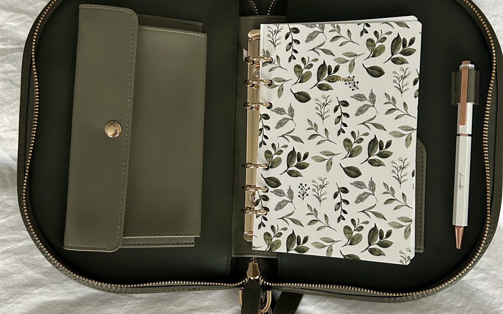 The Luna planner open with a floral insert and a pen