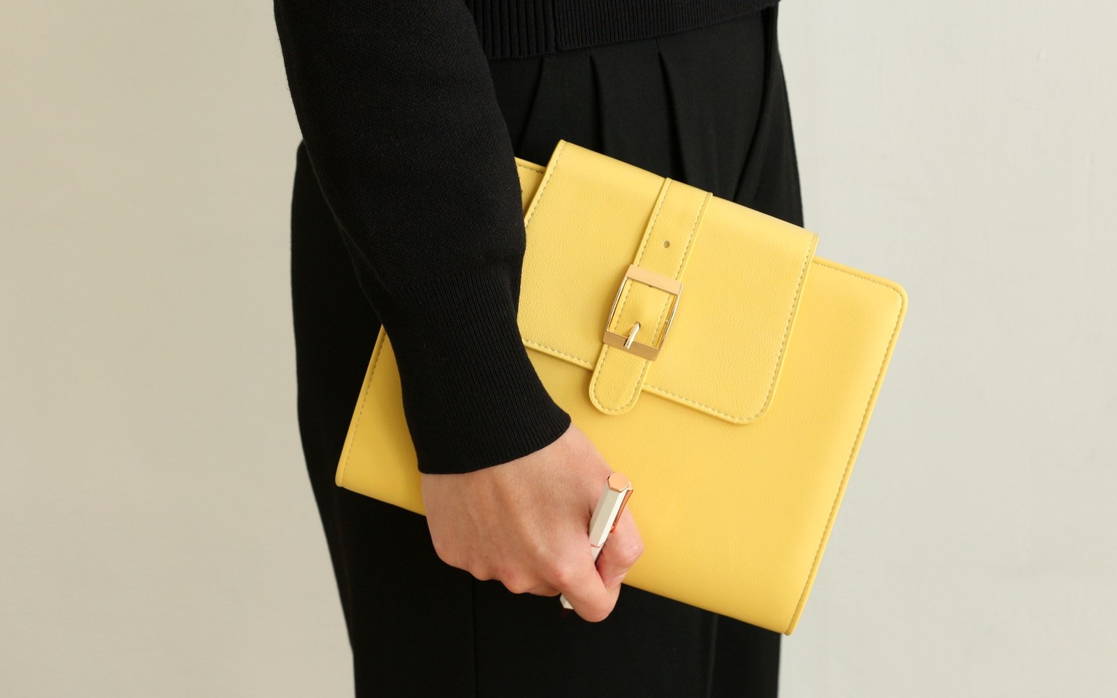 Woman holding an EGOSUNNY Belt planner against a white wall