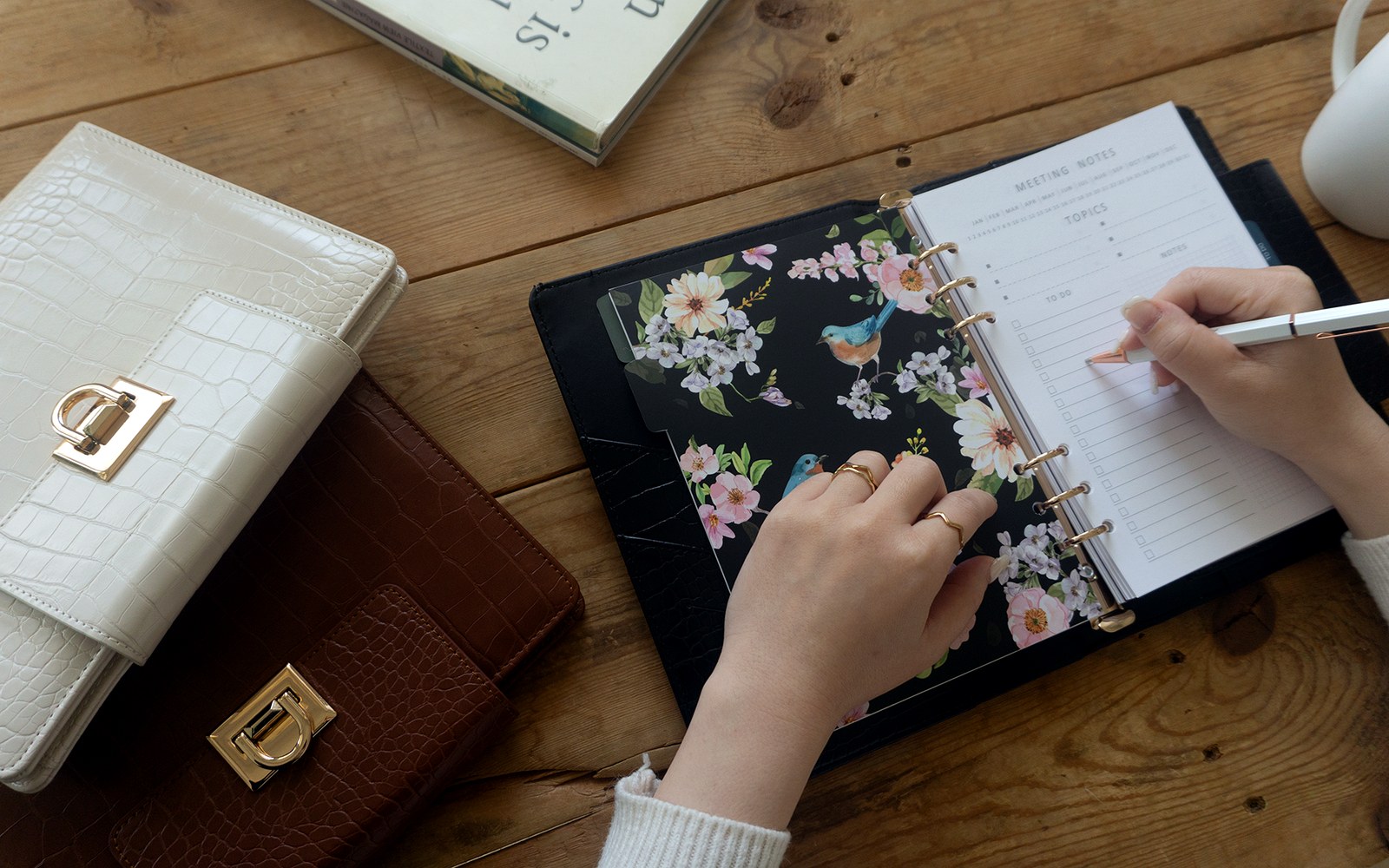 Writing in an EGOSUNNY Croco planner at a desk