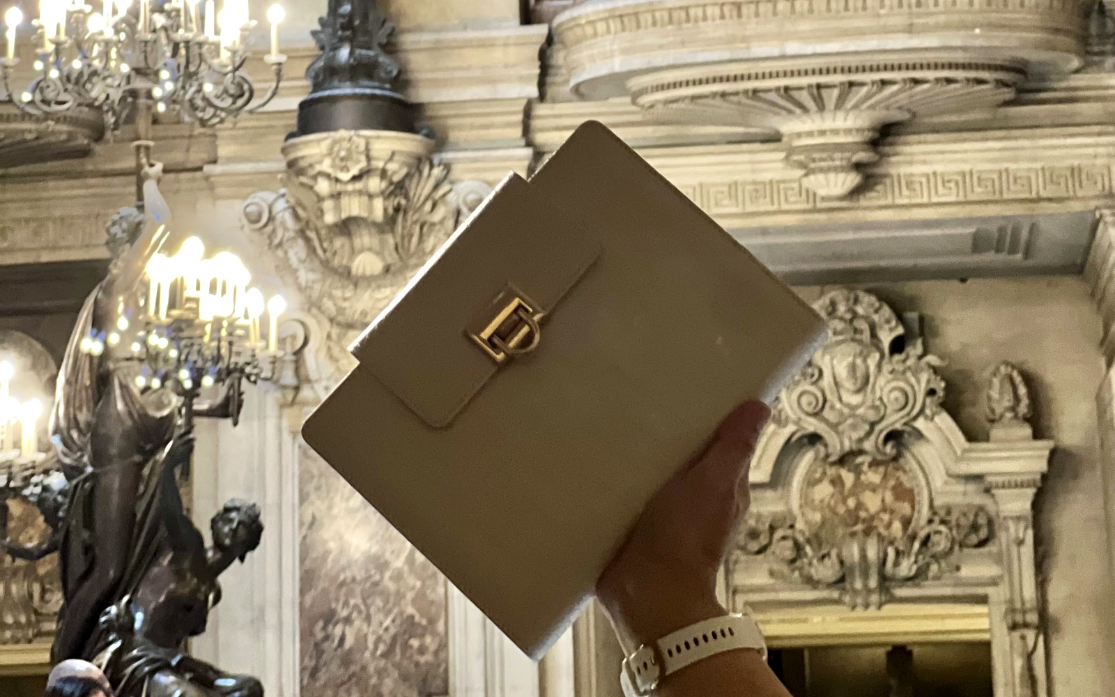 Holding an EGOSUNNY planner up in an ornate hall