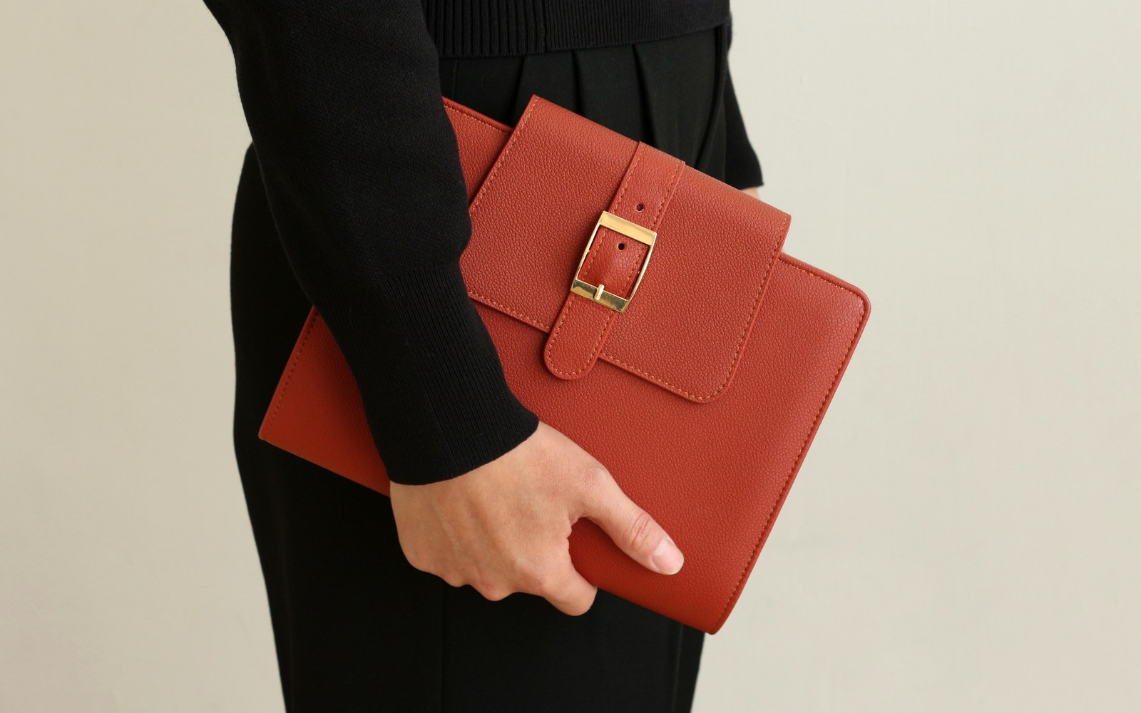 Woman holding a red EGOSUNNY Belt planner against a black outfit