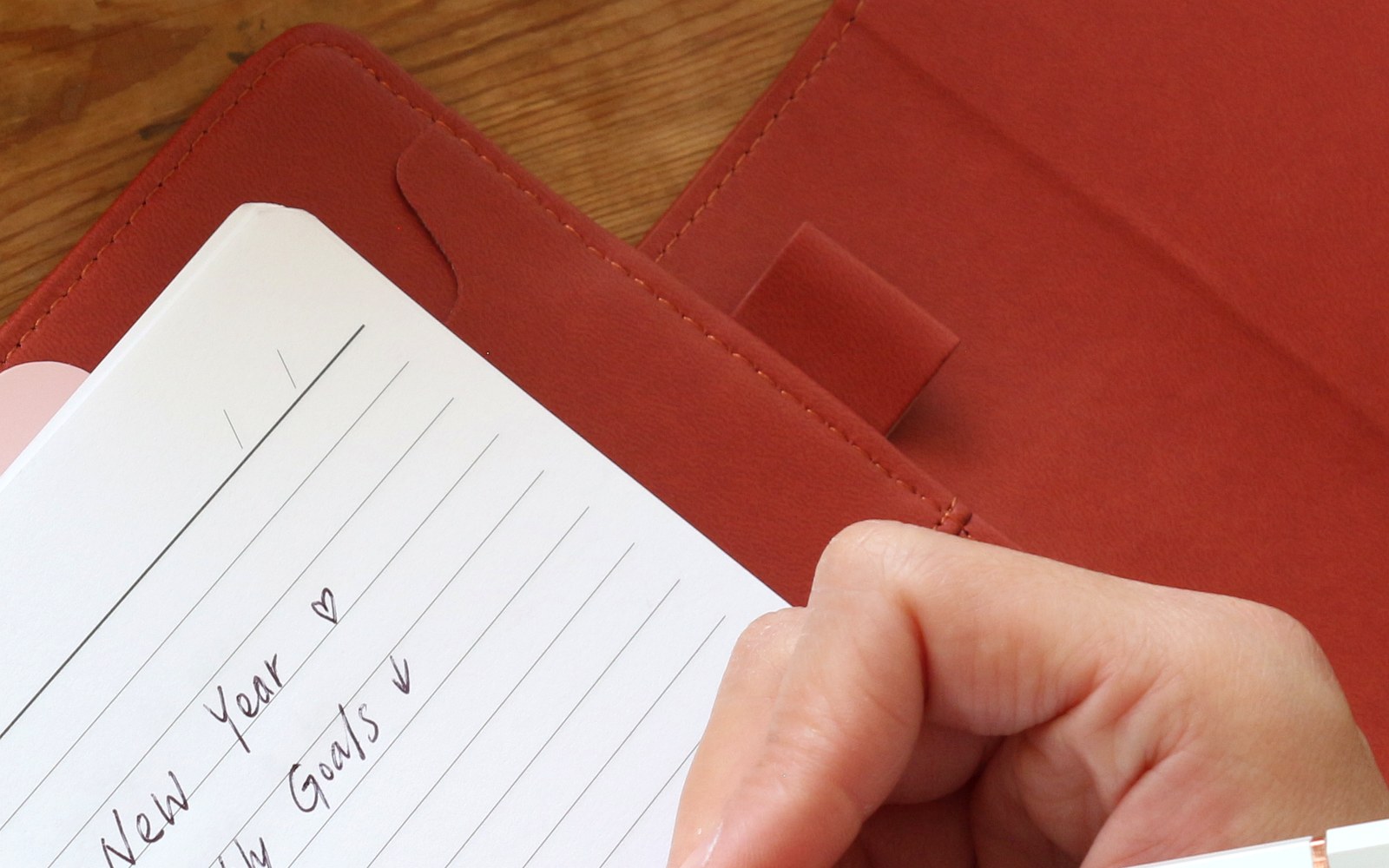 Writing New Year goals in a red EGOSUNNY Belt planner