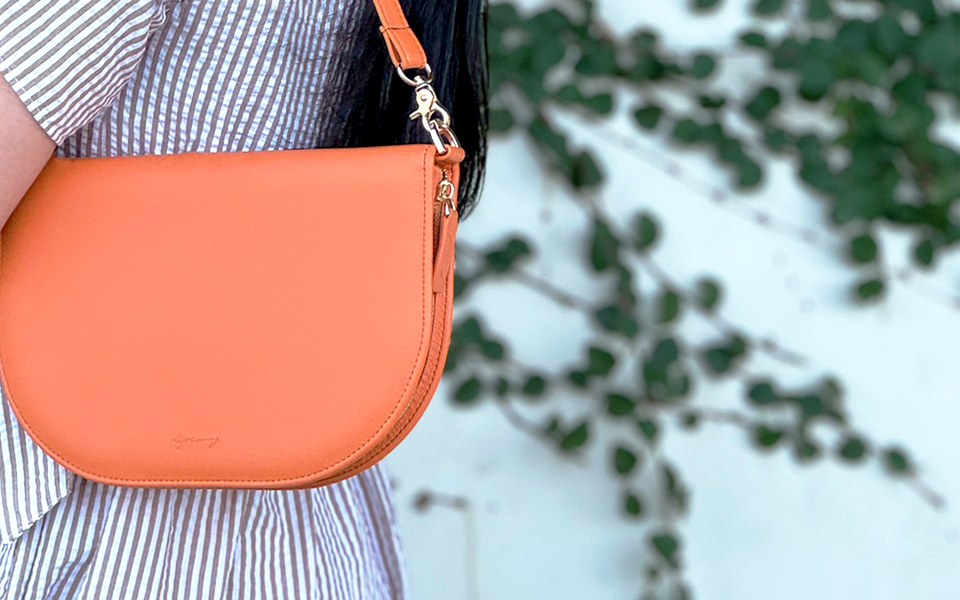 Woman carrying an orange EGOSUNNY Luna on her shoulder