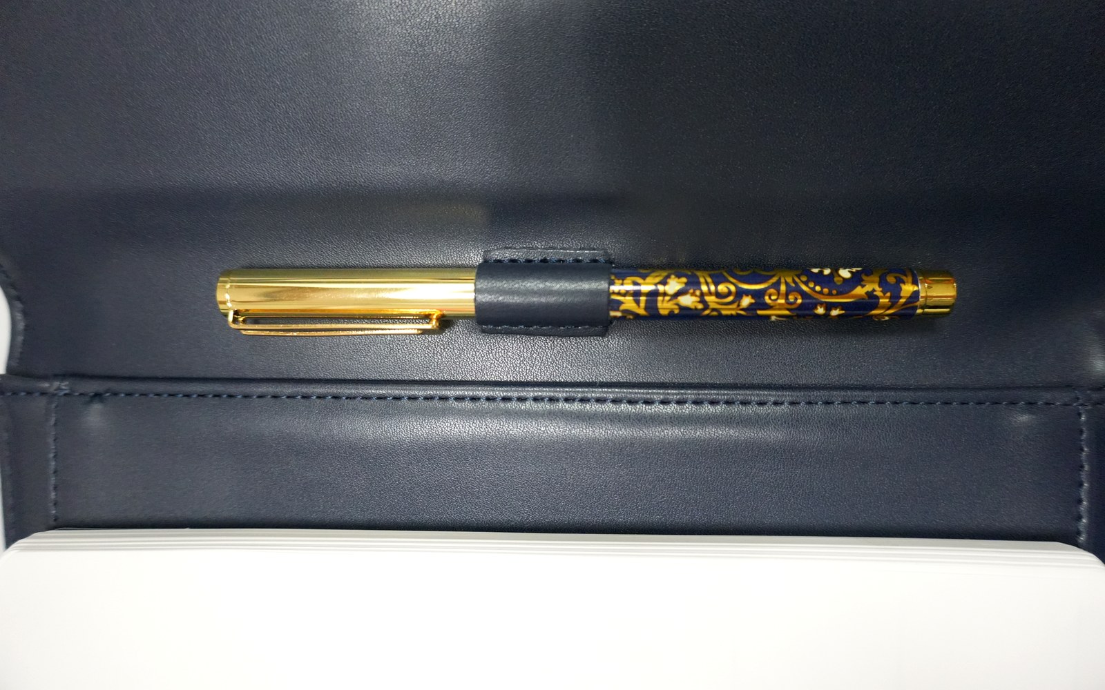 Close-up of a pen tucked inside a navy EGOSUNNY Terence planner