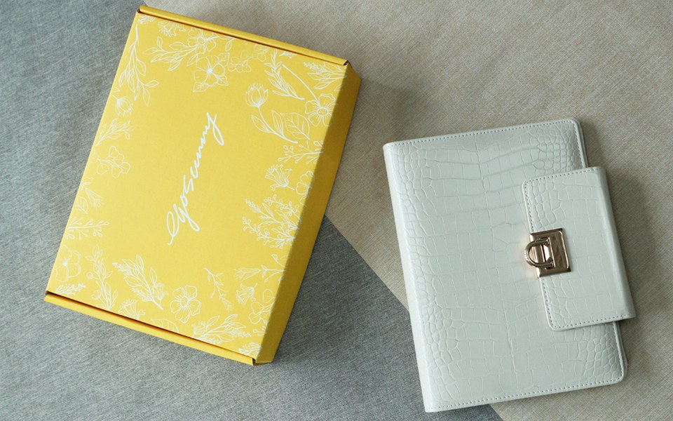 Pale EGOSUNNY Croco planner beside a yellow EGOSUNNY gift box