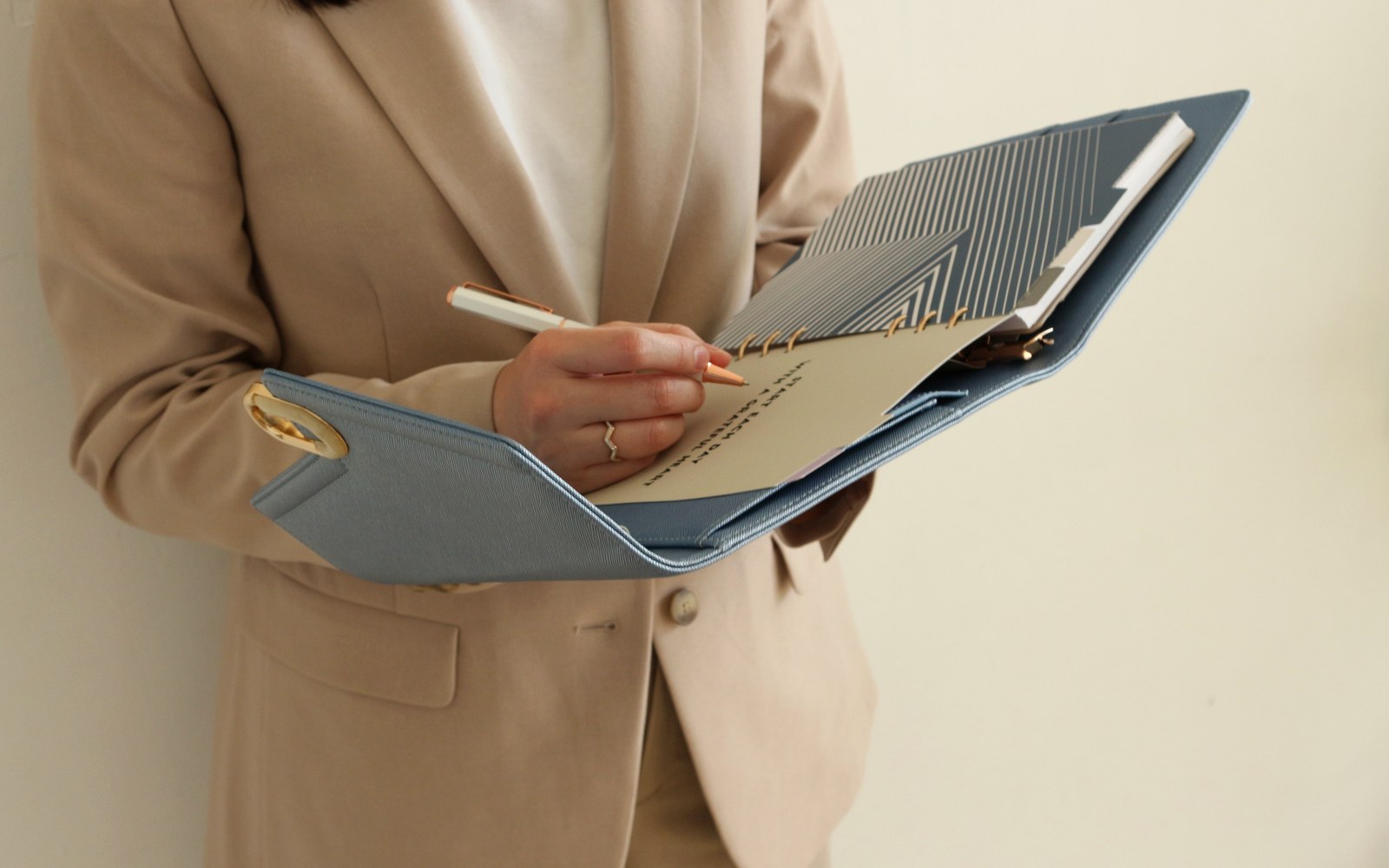 Woman in a blazer writing in an open EGOSUNNY planner