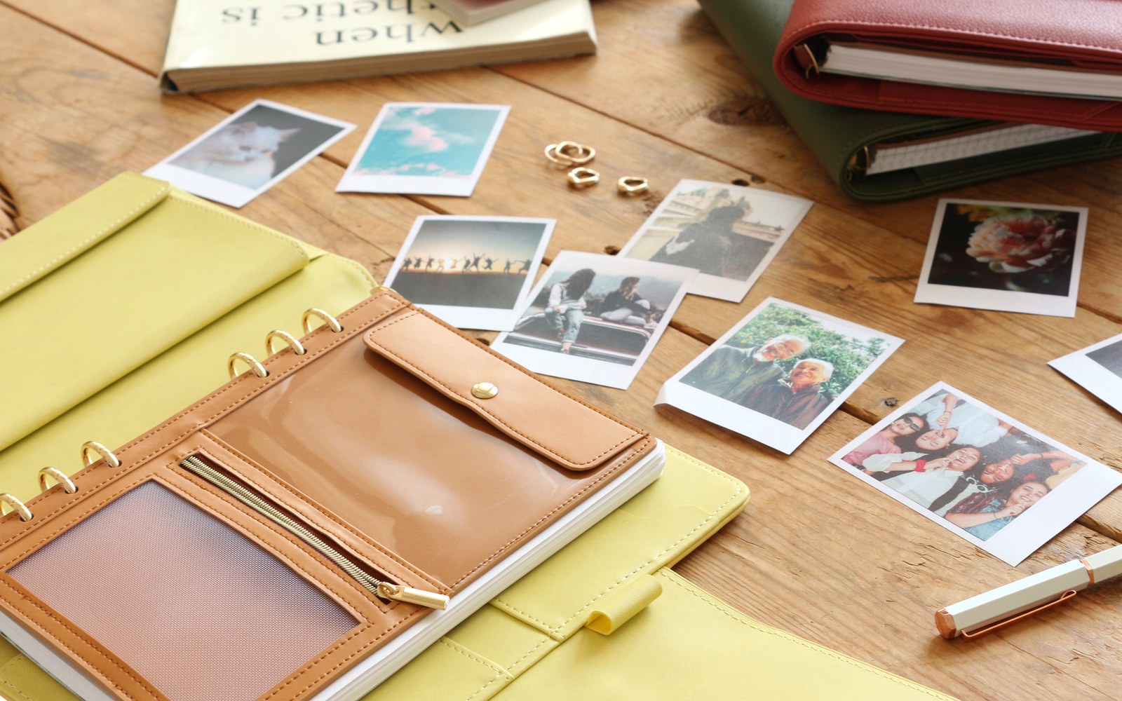 Open EGOSUNNY Belt planner surrounded by photos on a wooden table