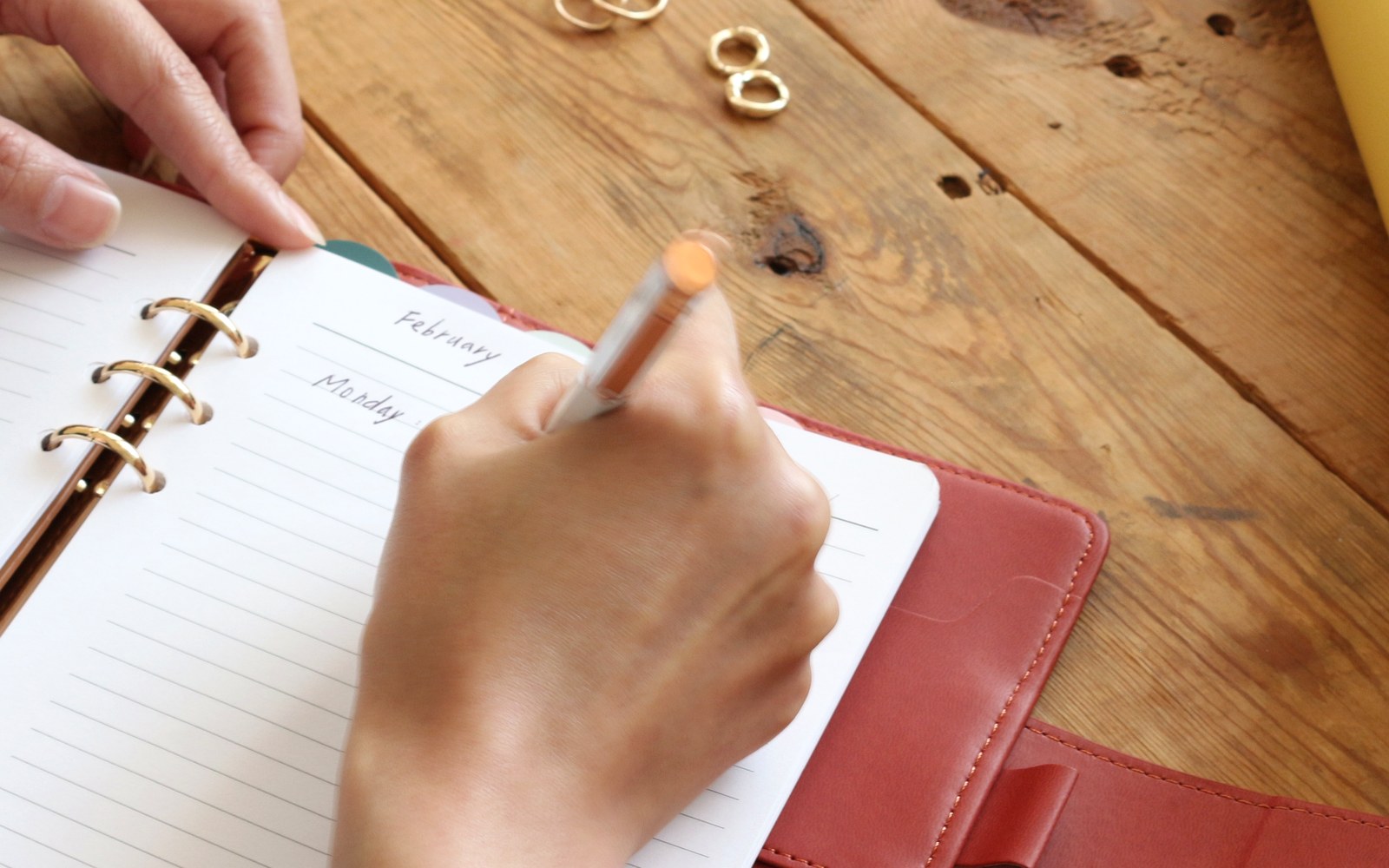 Hand writing a list in a red EGOSUNNY Belt planner