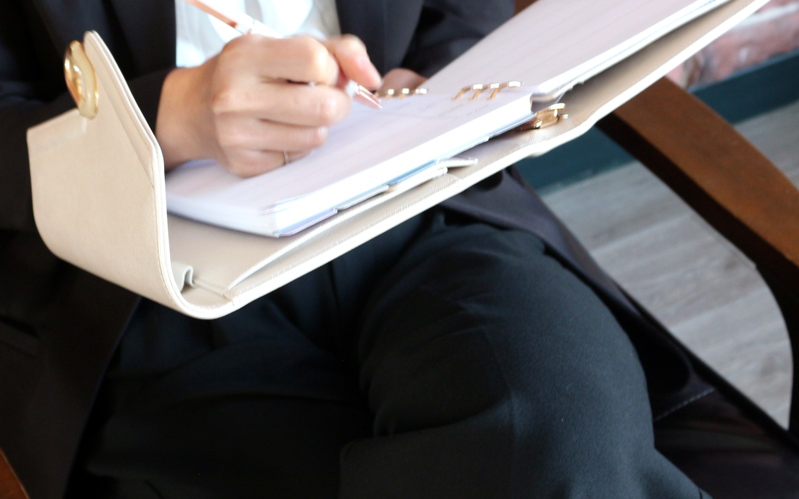 Woman in a blazer seated with an open EGOSUNNY planner on her lap