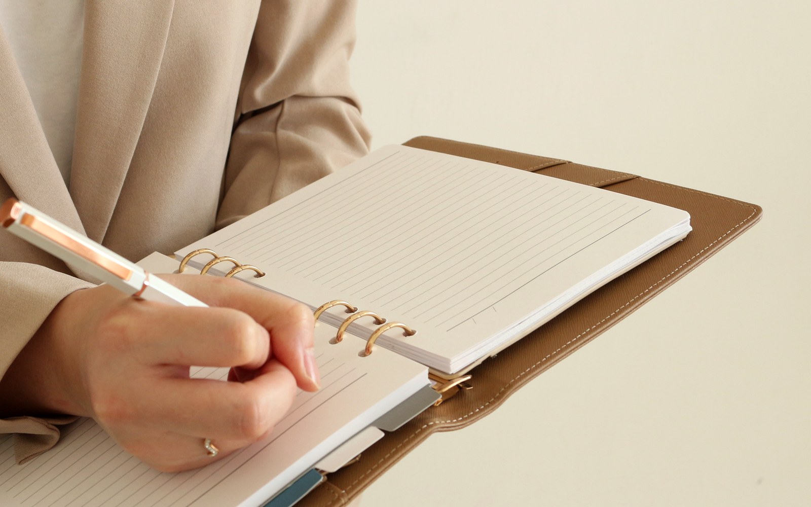 Woman in a blazer writing in an open EGOSUNNY planner