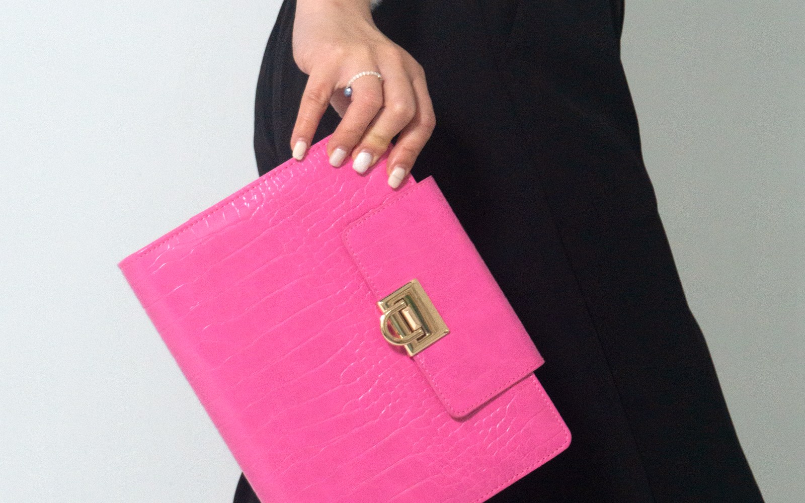 Woman in black trousers carrying a pink EGOSUNNY Croco planner