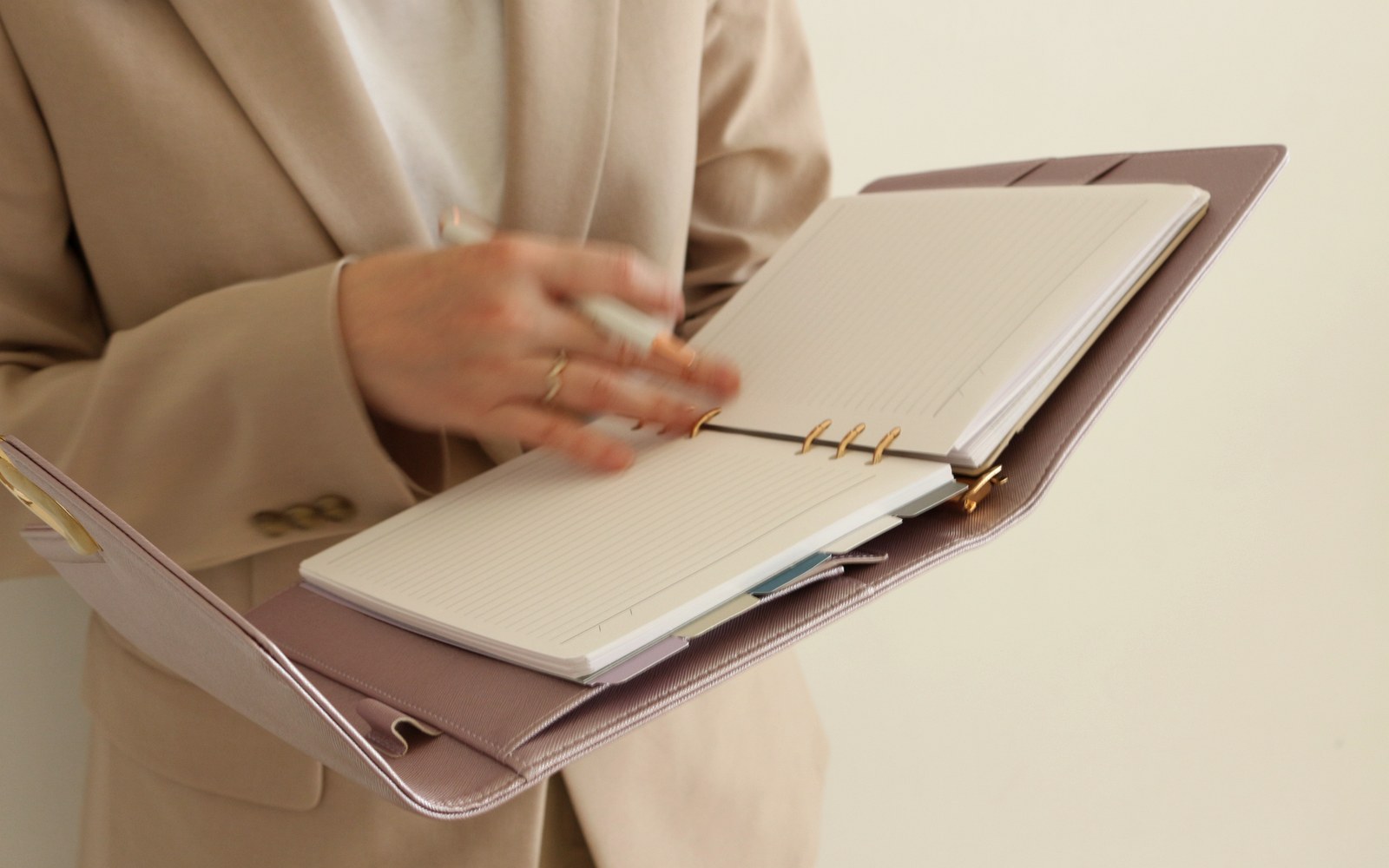Woman in a beige blazer writing in an EGOSUNNY planner