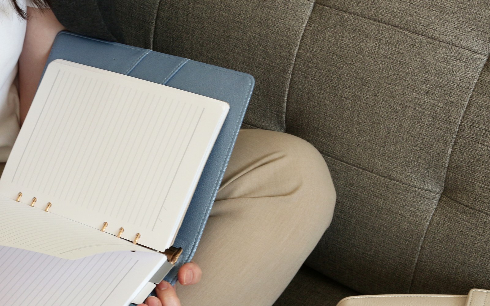Blue EGOSUNNY Eclair planner open to a lined page on a sofa