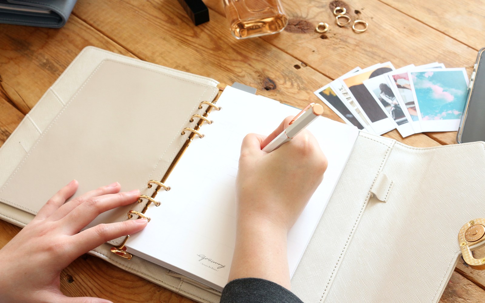 Writing in an EGOSUNNY planner on a wooden table