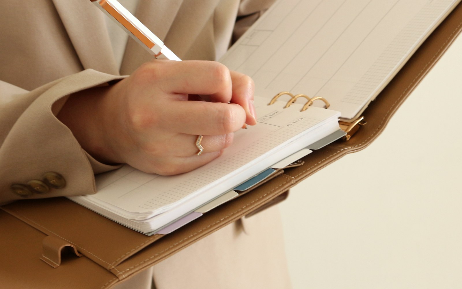 Woman in a blazer writing in an open EGOSUNNY planner