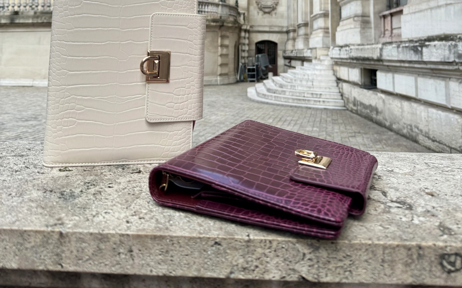 Cream and plum EGOSUNNY Croco planners on a stone ledge near a classic building