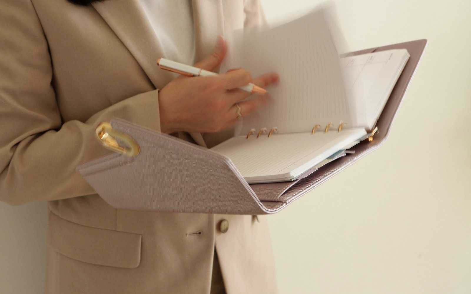 Woman in a blazer writing in a taupe EGOSUNNY L’Éclair planner