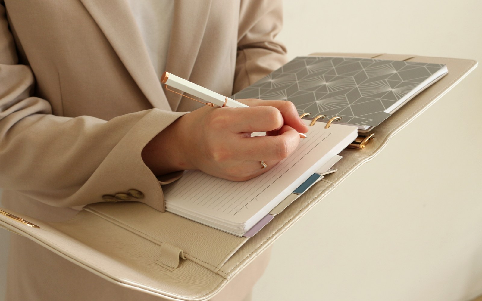 Woman writing in a cream EGOSUNNY L’Éclair planner with a patterned divider