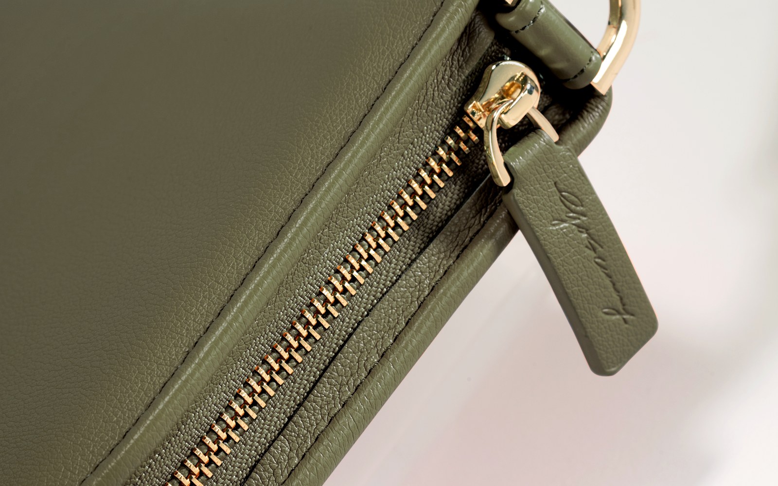 Close-up of the zipper and strap on an olive EGOSUNNY Luna