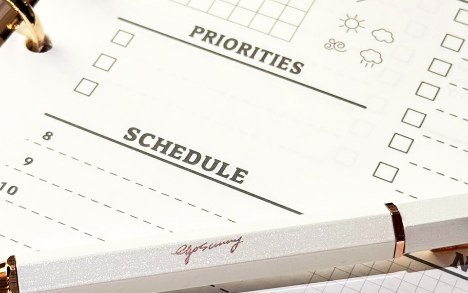 Printed weekly planning page with a pen