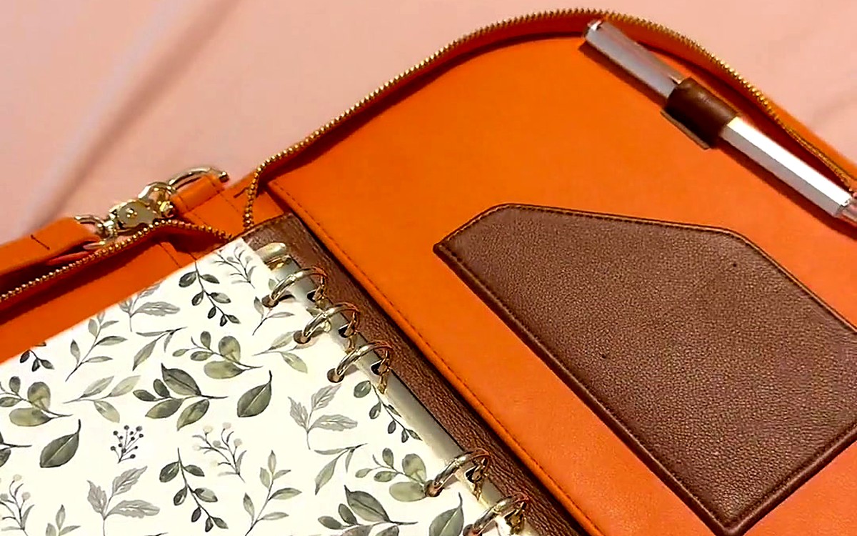 Open tan EGOSUNNY planner with a leaf divider and silver pen