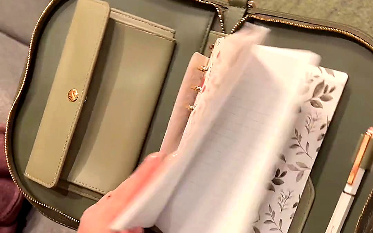 Hand flipping clear sleeves inside an olive EGOSUNNY planner