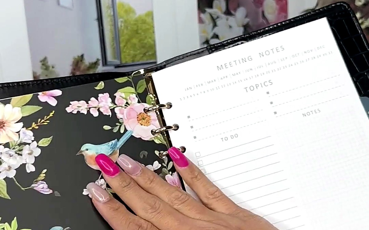 Blossom divider beside a meeting notes page in a silver-ring planner