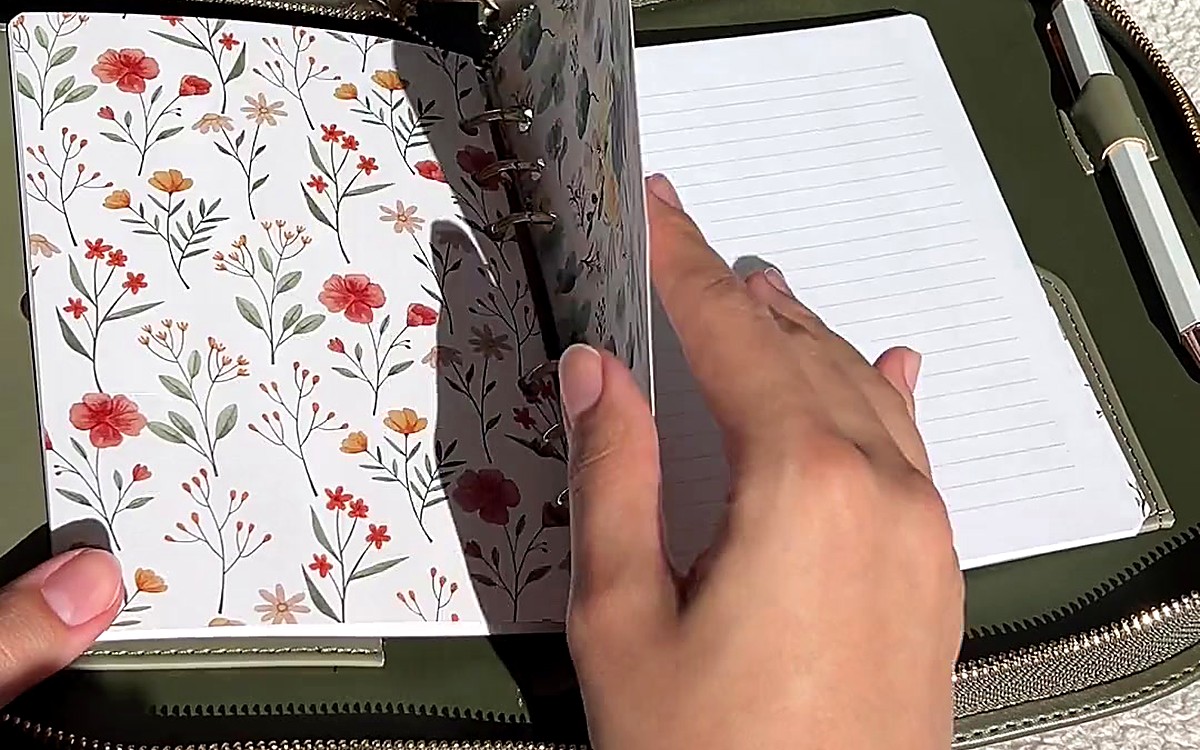 Hands turning pages inside a green zippered EGOSUNNY planner