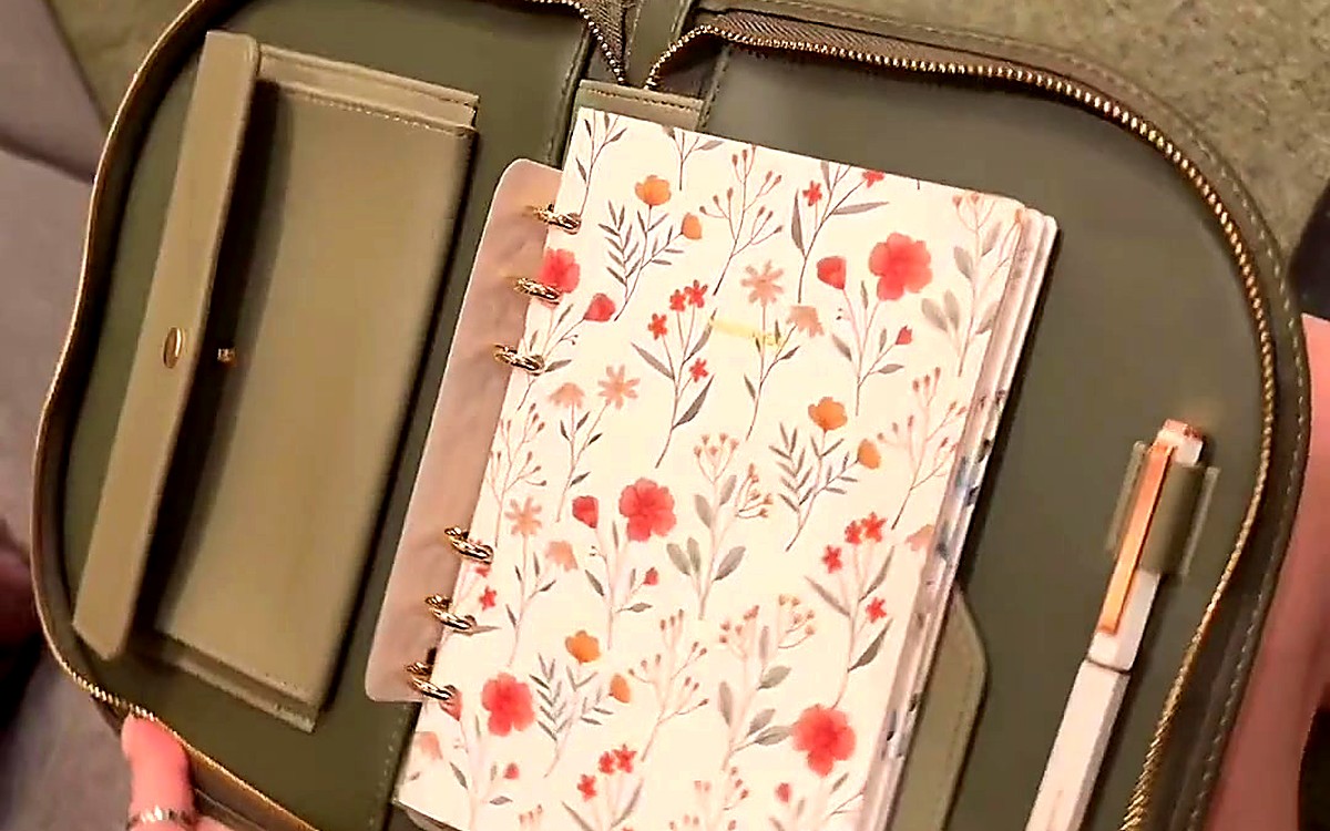 Open olive EGOSUNNY planner with card pockets, floral pages and a pen