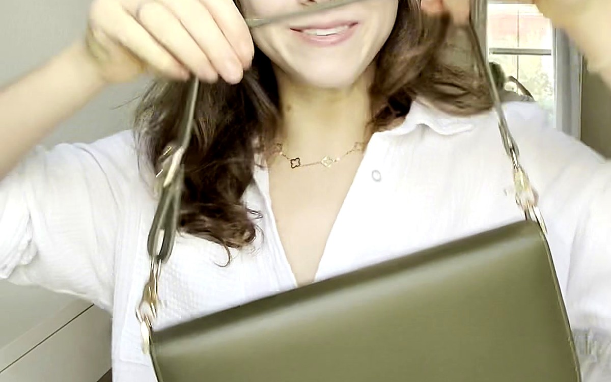 Woman carrying an olive EGOSUNNY bag with a chain strap
