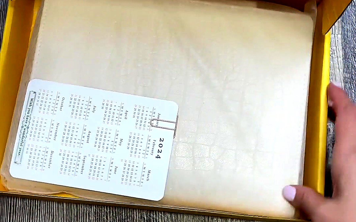 Wrapped planner with a small calendar card inside a gift box
