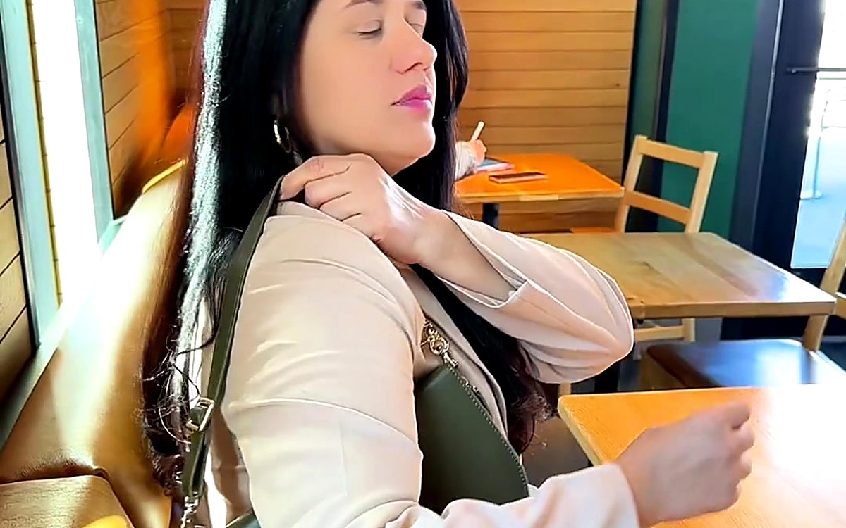 Woman writing in a planner at a café table