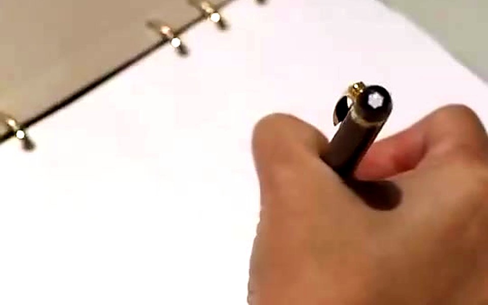Hand writing on a blank planner page with a pen