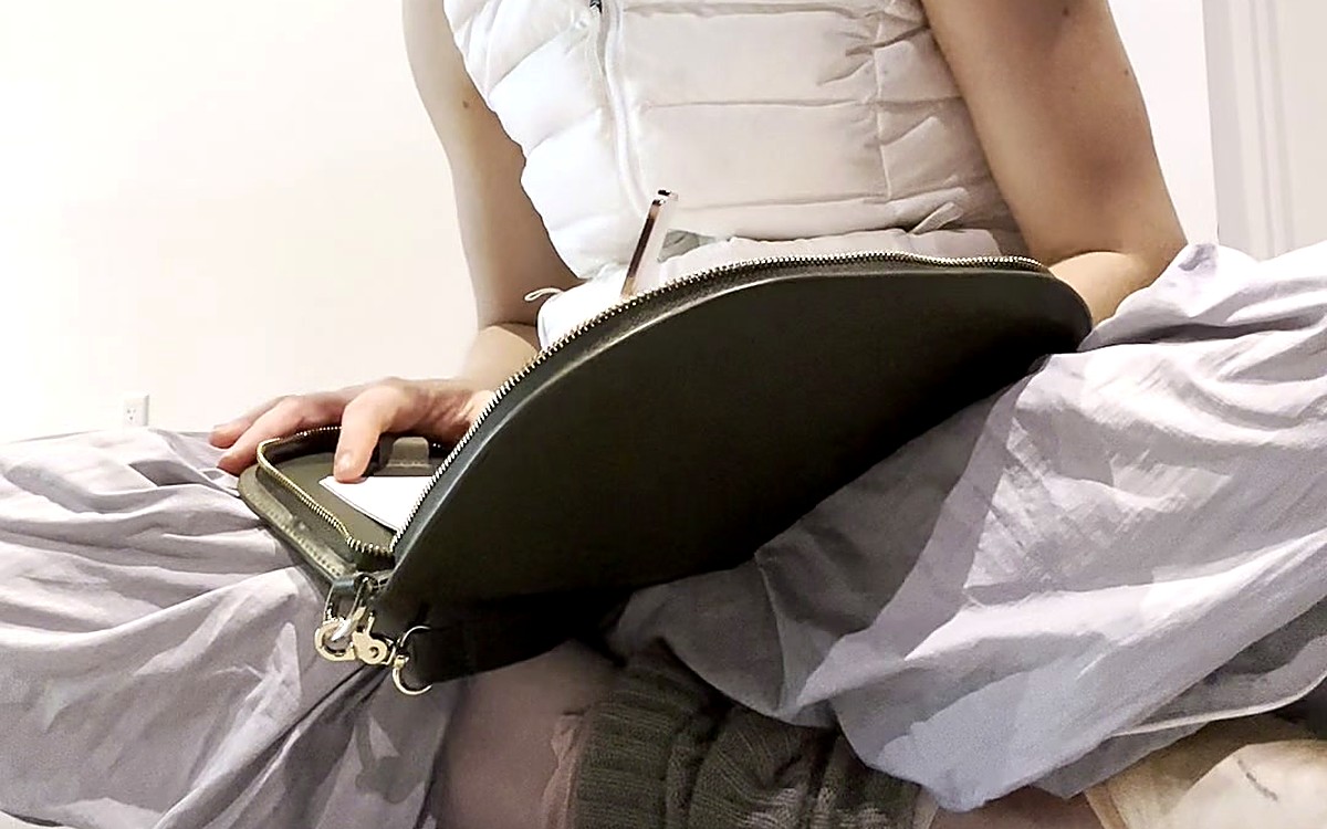 Woman sitting with a green EGOSUNNY bag-style planner on her lap