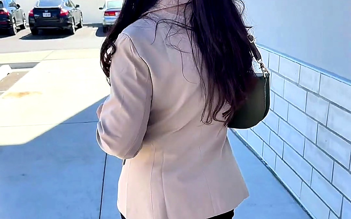Woman walking outside with a planner bag on her shoulder