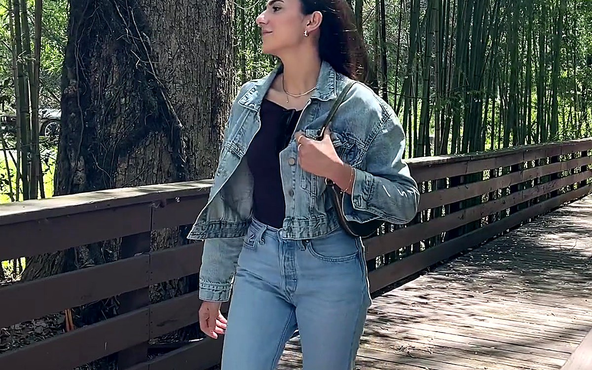 Woman in a denim jacket walking on a forest path