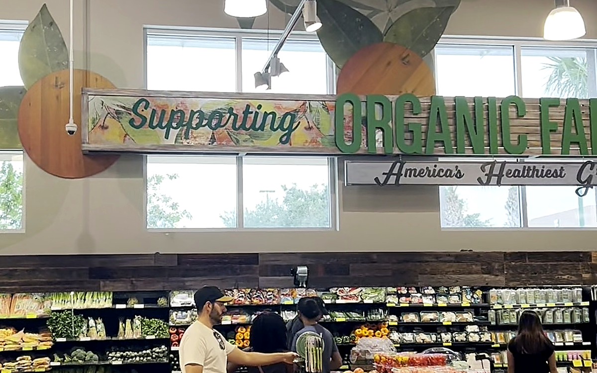 Supermarket aisle with fresh produce signs