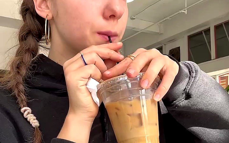 Woman sipping an iced coffee
