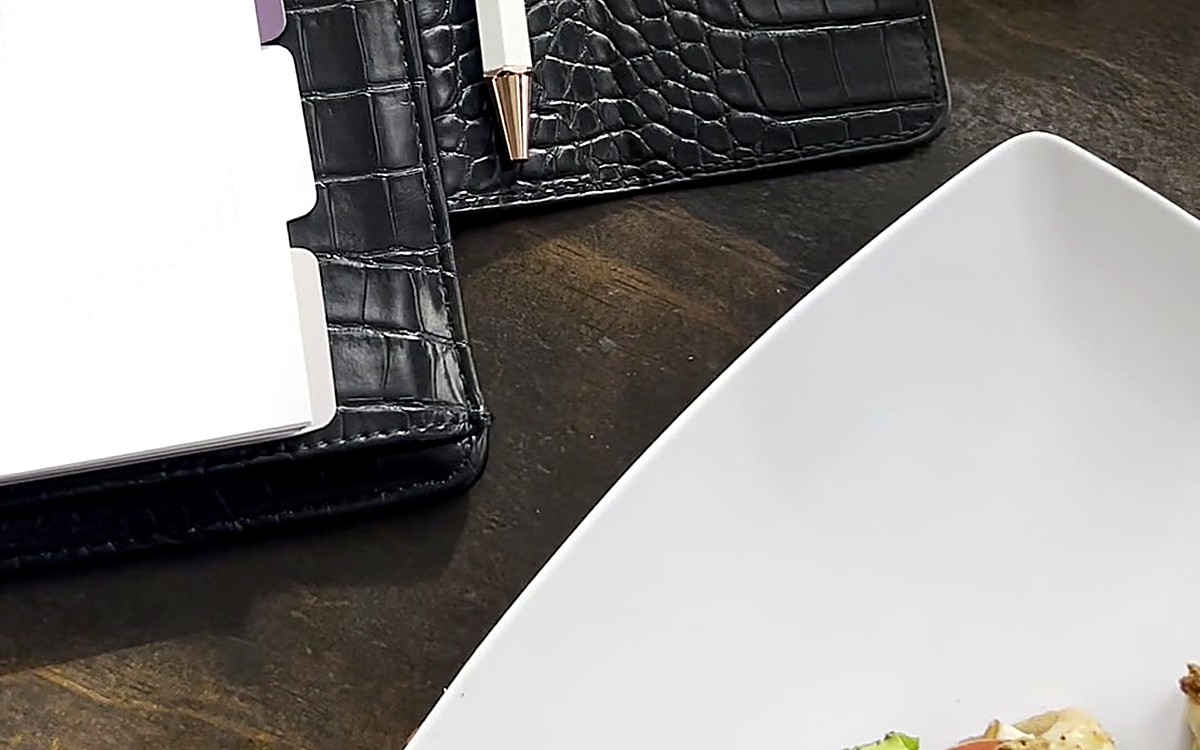 Black EGOSUNNY planner next to a plate at a meal