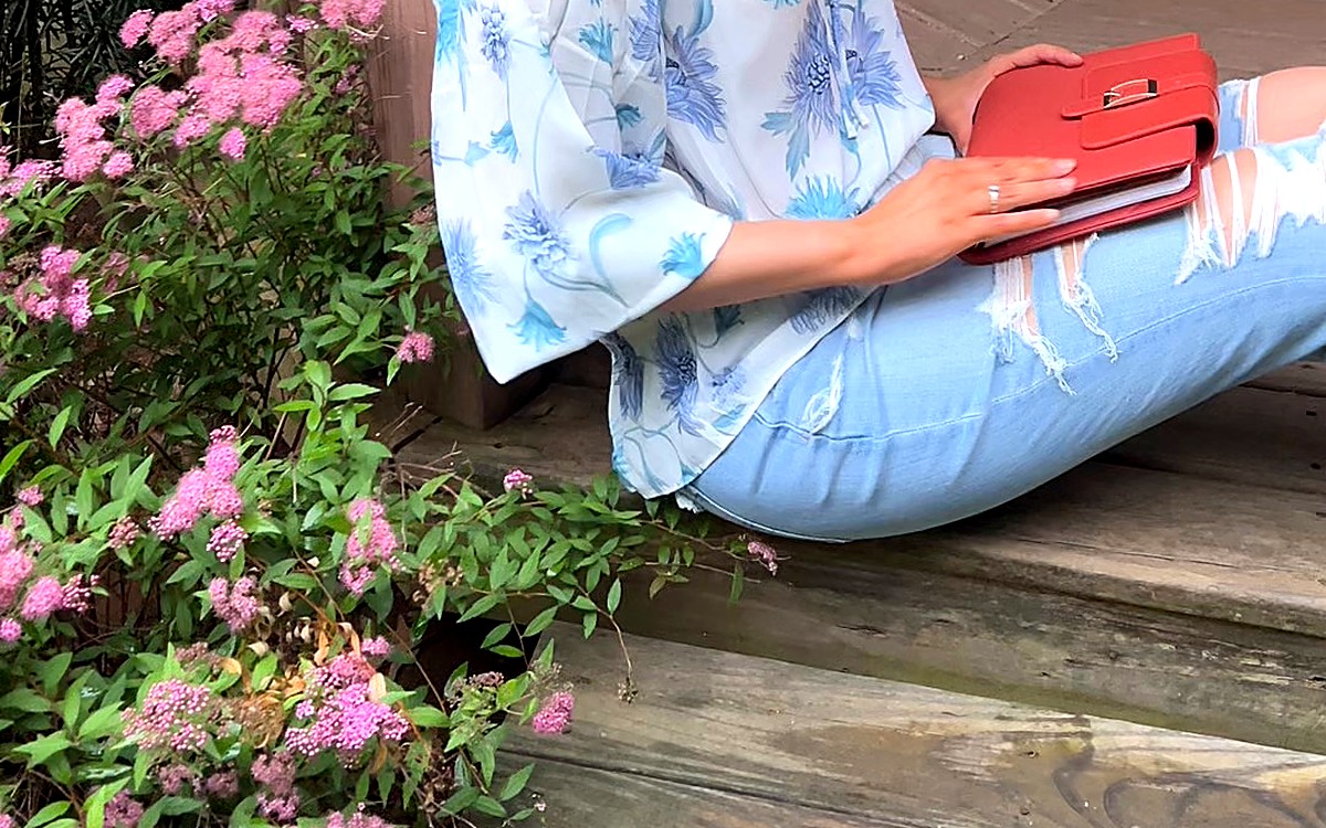 Woman reading a planner outdoors among flowers