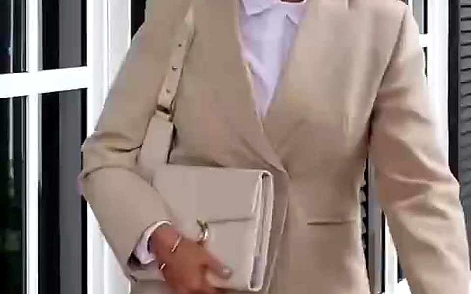 Woman in a beige blazer carrying a cream EGOSUNNY planner