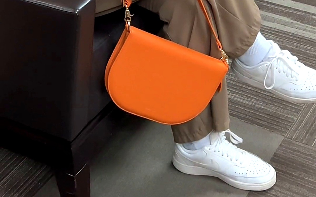 Orange EGOSUNNY bag-style planner held by its strap