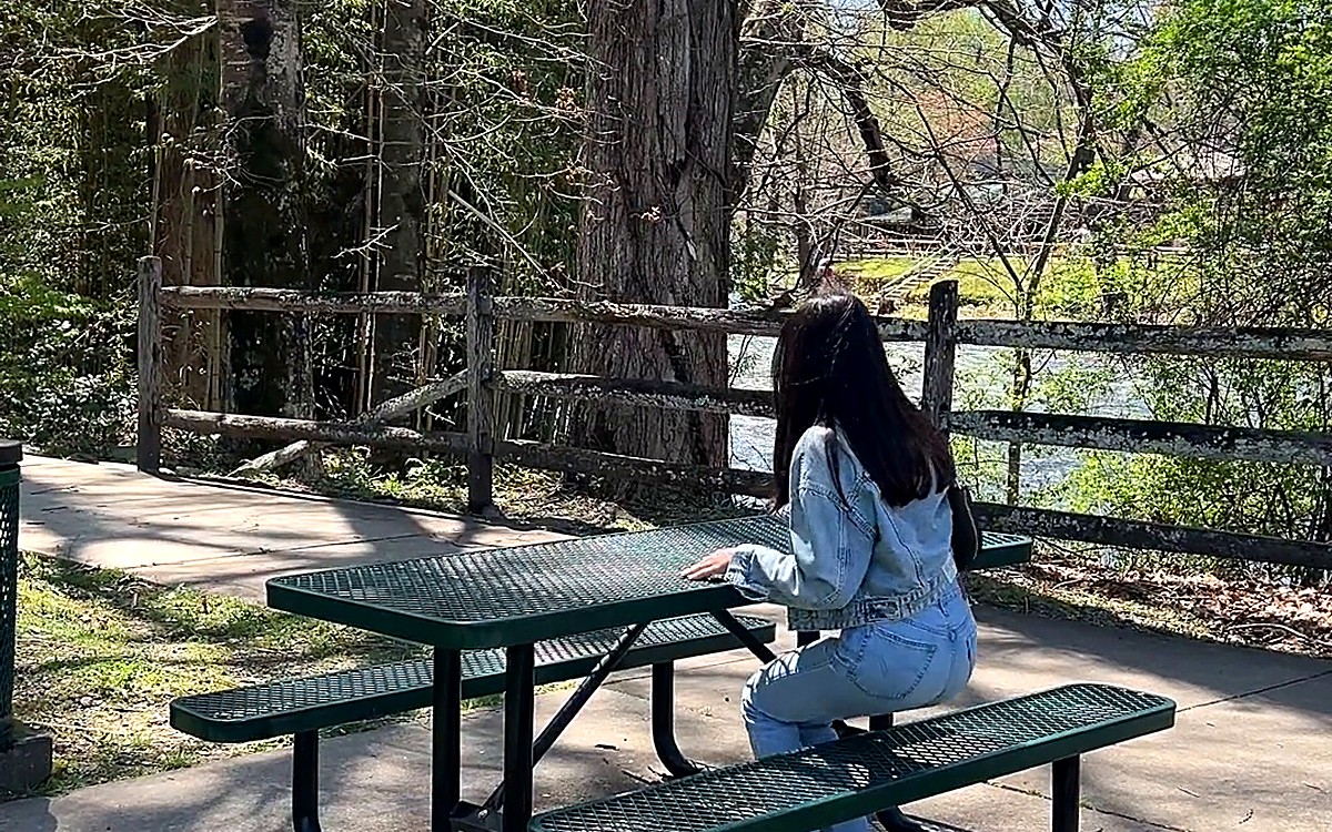 Woman sitting at a picnic table in a park